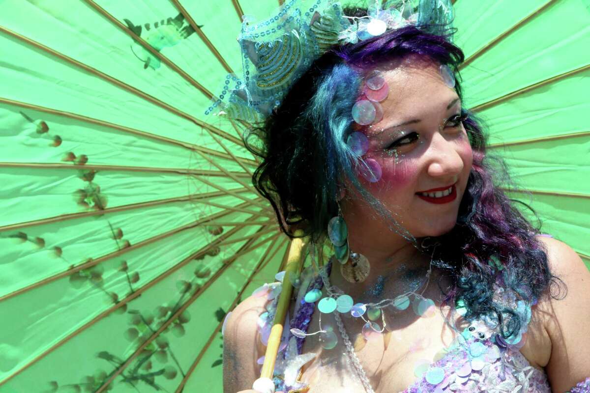 A woman dressed as a mermaid poses for photos in the staging area ahead of the 30th annual Mermaid parade Saturday, June 23, 2012 in New York's Coney Island.
