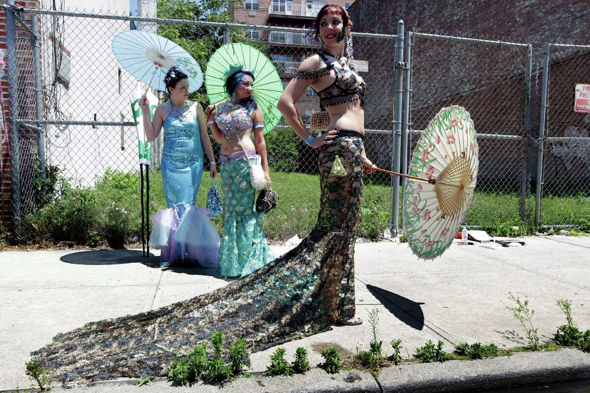 Jessica Layman, foreground, and other members of the Occupy Atlantis group pose for photographers in the staging area ahead of the 30th annual Mermaid parade Saturday, June 23, 2012, it New York's Coney Island.