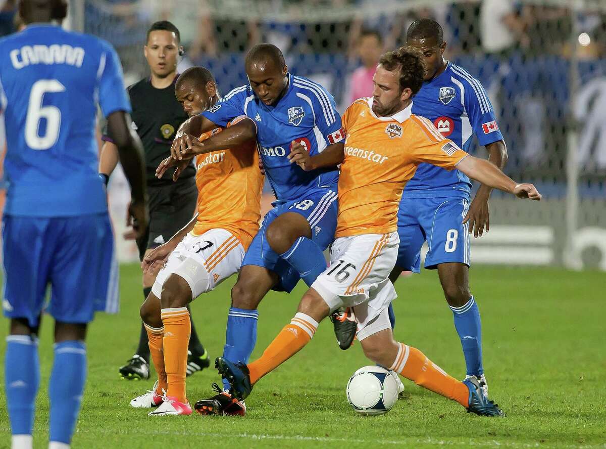 MONTREAL, CANADA - JUNE 23: Collen Warner #18 of the Montreal Impact controls the ball against Luiz Camargo #17 and Adam Moffat #16 of the Houston Dynamo during the MLS match at Saputo Stadium on June 23 2012 in Montreal, Quebec, Canada.