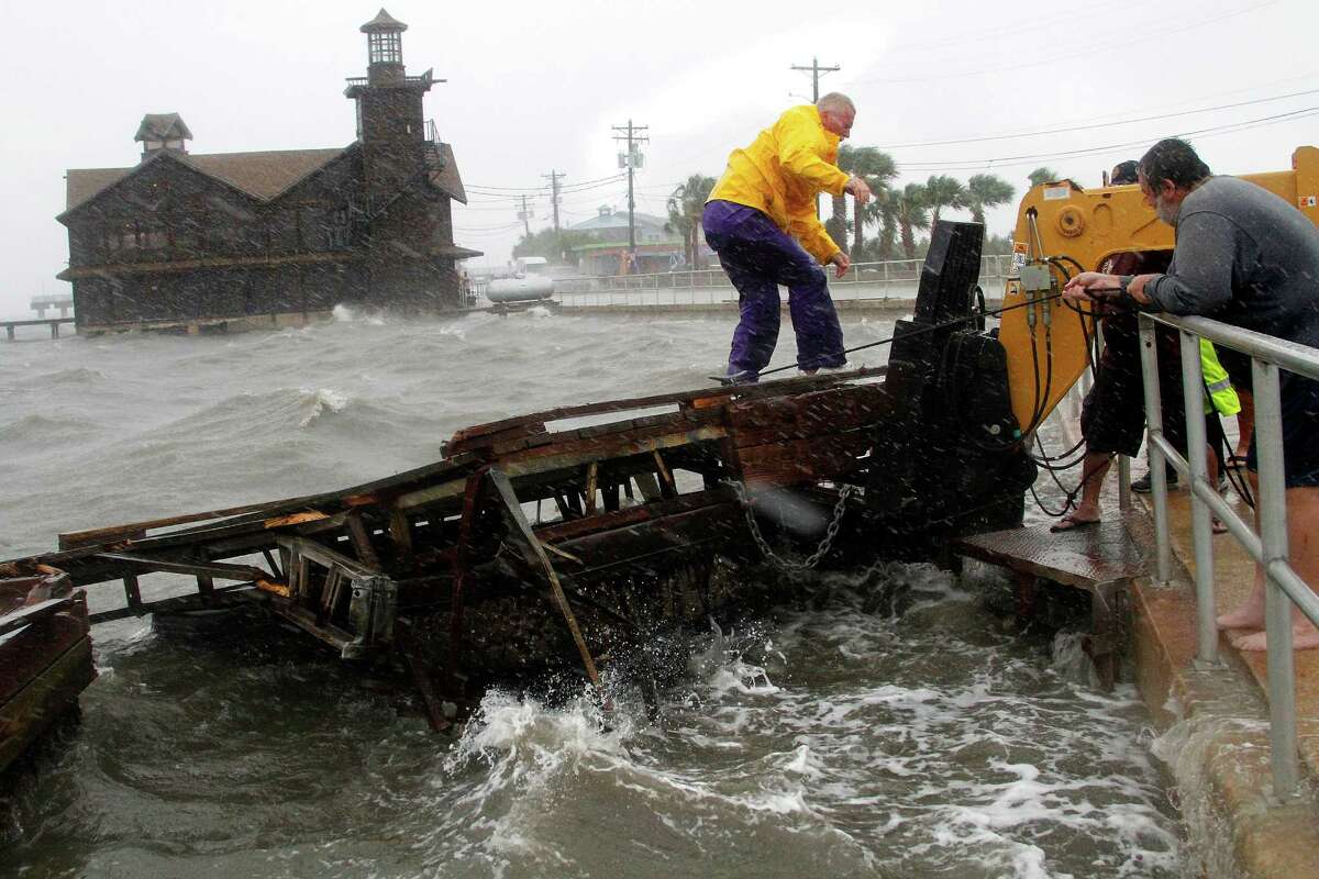 FILE- In this Sunday, June 24, 2012 file photo, Cedar Key Fire Chief Robert Robinson walks on a section of a floating dock that broke loose during a storm surge from Tropical Storm Debby in Cedar Key, Fla. The price of oil declined Monday, June 25, 2012, as Spain's banking crisis added to concerns about the troubled European economy and Tropical Storm Debby appeared to be shifting away from the heart of America's oil production in the Gulf of Mexico.