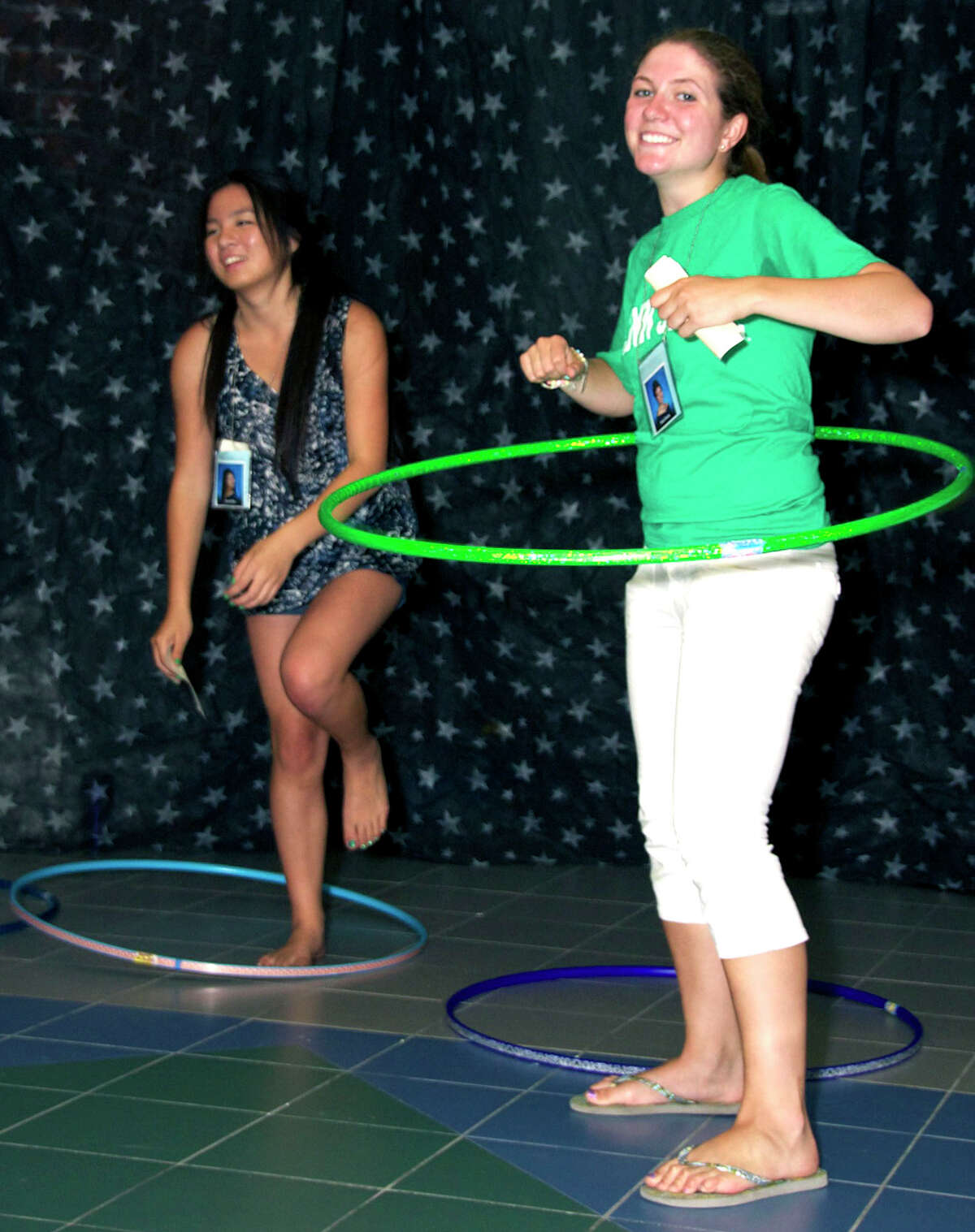 Faith Eherts demonstrates her prowess with the Hula Hoop while Annie Mao's effort meets its demise during the New Milford High School Grad Party, June 23, 2012 at the school.