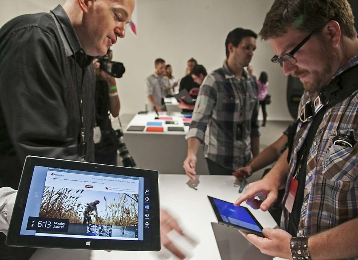 Microsoft Corp.'s Surface tablet computers, aiming to compete with Apple's iPad, are displayed at Hollywood's Milk Studios in Los Angeles Monday, June 18, 2012. The 9.3-millimeter thick tablet comes with a kickstand to hold it upright and keyboard that is part of the device's cover. (AP Photo/Damian Dovarganes)