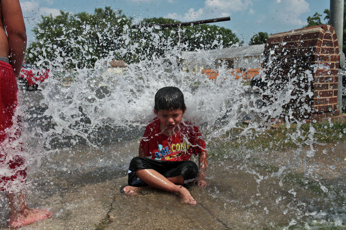 Josiah Castillo, 6, plays in the water flowing from a hydrant being flushed and tested by San Antonio Water System on a cul-de-sac in San Antonio on Wednesday, June 27, 2012.