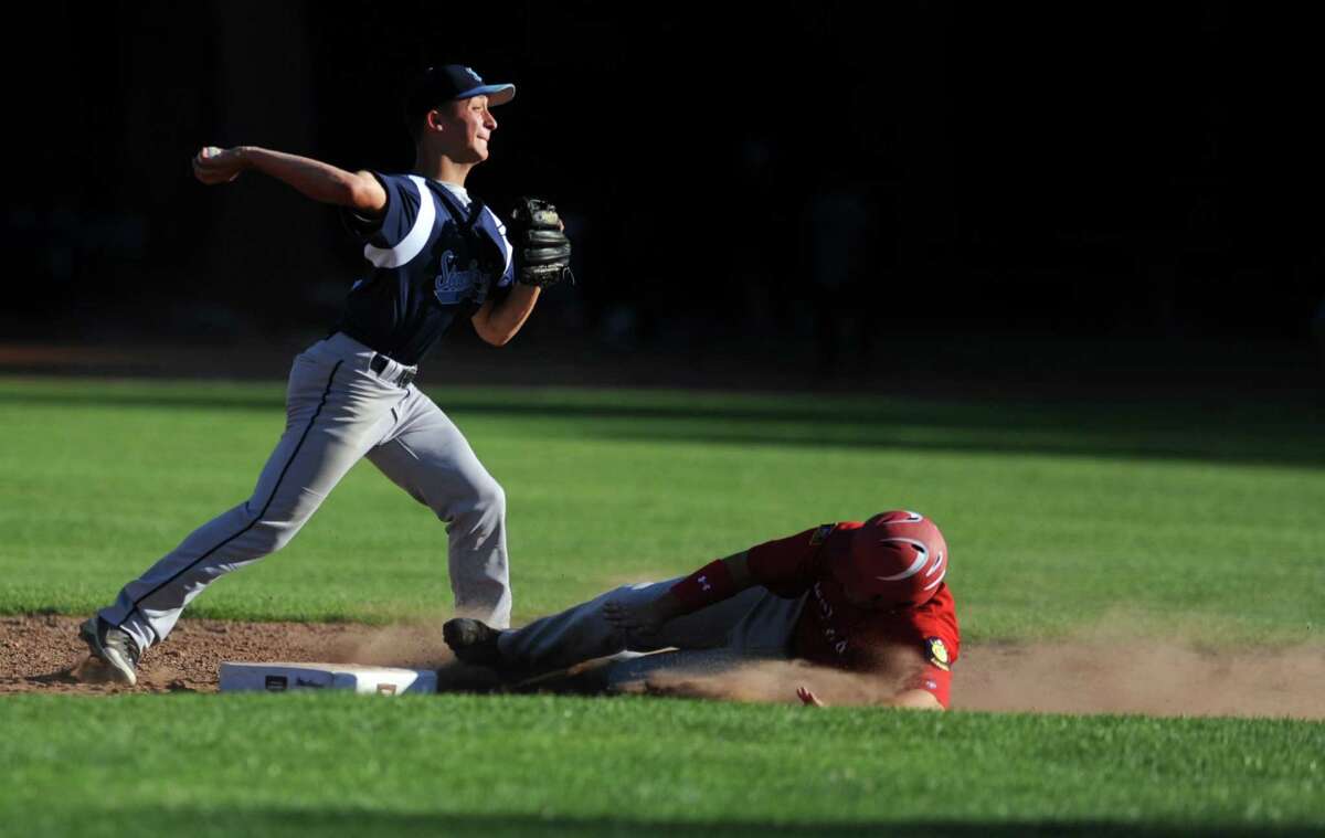 Stamford's Mike Palomba throws to first for a double play as Fairfield's Jay Sullivan slides to second Wednesday, June 27, 2012 during their American Legion baseball game at Owen Fish Park in Fairfield, Conn.