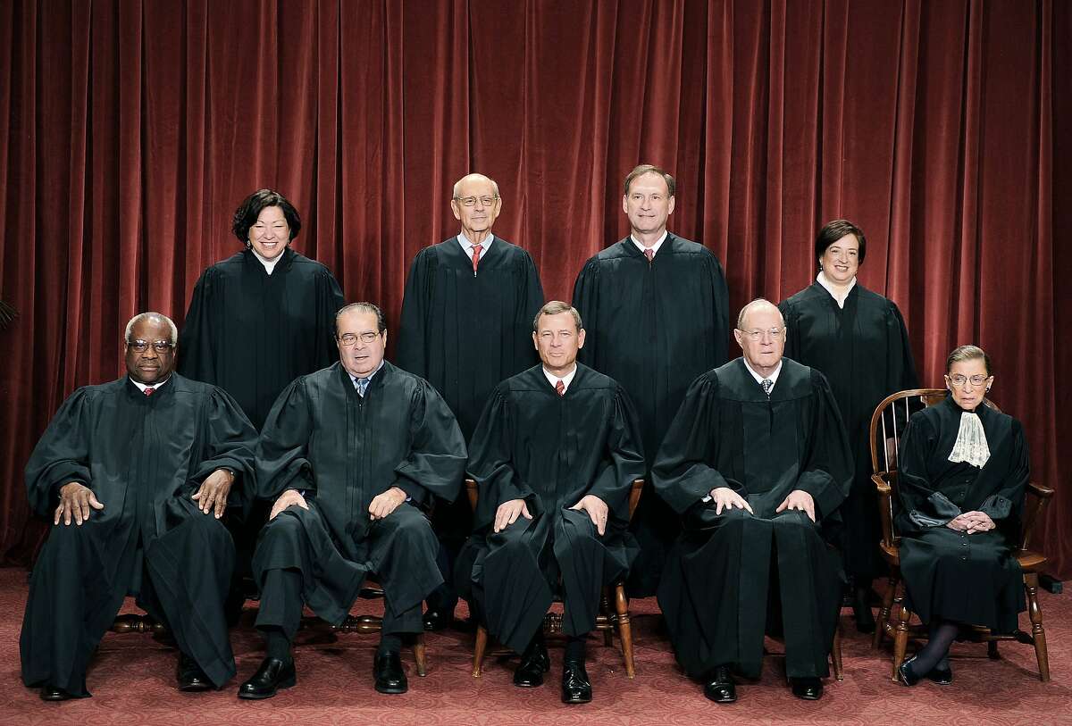 (FILES)The Justices of the US Supreme Court sit for their official photograph in this October 8, 2010 file photo at the Supreme Court in Washington, DC. The US Supreme Court struck down most of Arizona's controversial new immigration law on June 25, 2012, but let stand a key provision allowing officers to do spot checks of people's identity papers. The Arizona law has aroused intense controversy because of a particular provision, 2(B), that requires police to stop and demand proof of citizenship of anyone they suspect of being illegal, even without probable cause. Front row (L-R): Associate Justice Clarence Thomas, Associate Justice Antonin Scalia, Chief Justice John G. Roberts, Associate Justice Anthony M. Kennedy and Associate Justice Ruth Bader Ginsburg. Back Row (L-R): Associate Justice Sonia Sotomayor, Associate Justice Stephen Breyer, Associate Justice Samuel Alito Jr. and Associate Justice Elena Kagan. AFP PHOTO / TIM SLOAN/FILESTIM SLOAN/AFP/GettyImages