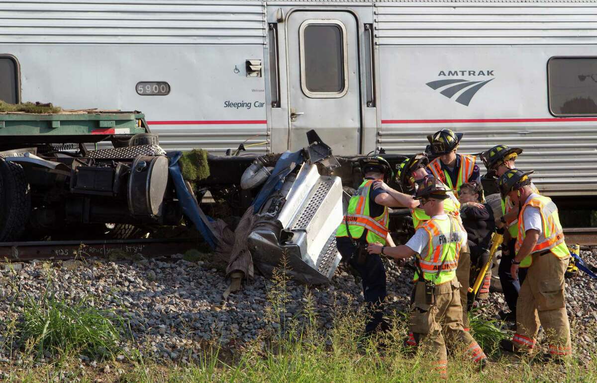 Emergency personnel remove an injured passenger from an Amtrak train that collided Friday with a tractor-trailer rig on Union Pacific tracks in Arlington.