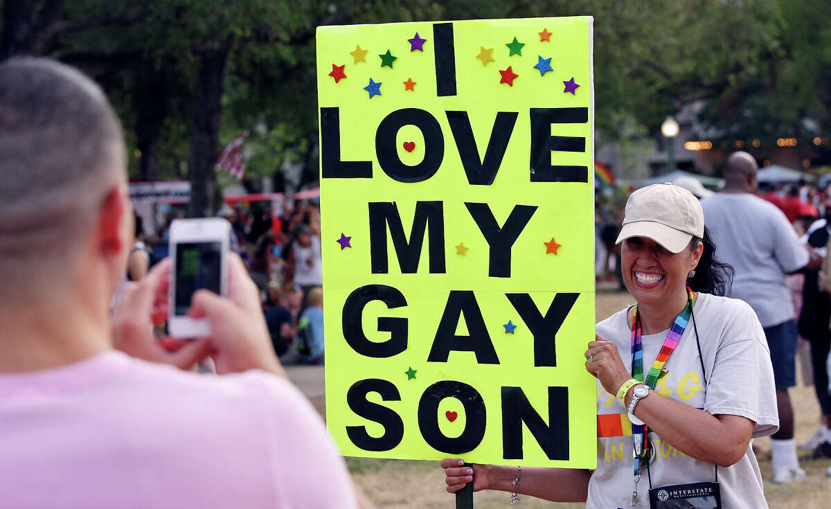 Norma Ortega poses for photos while holding a sign for her son and his boyfriend during the Pride Bigger Than Texas Festival & Parade held Saturday June 30, 2012 at Crockett Park.