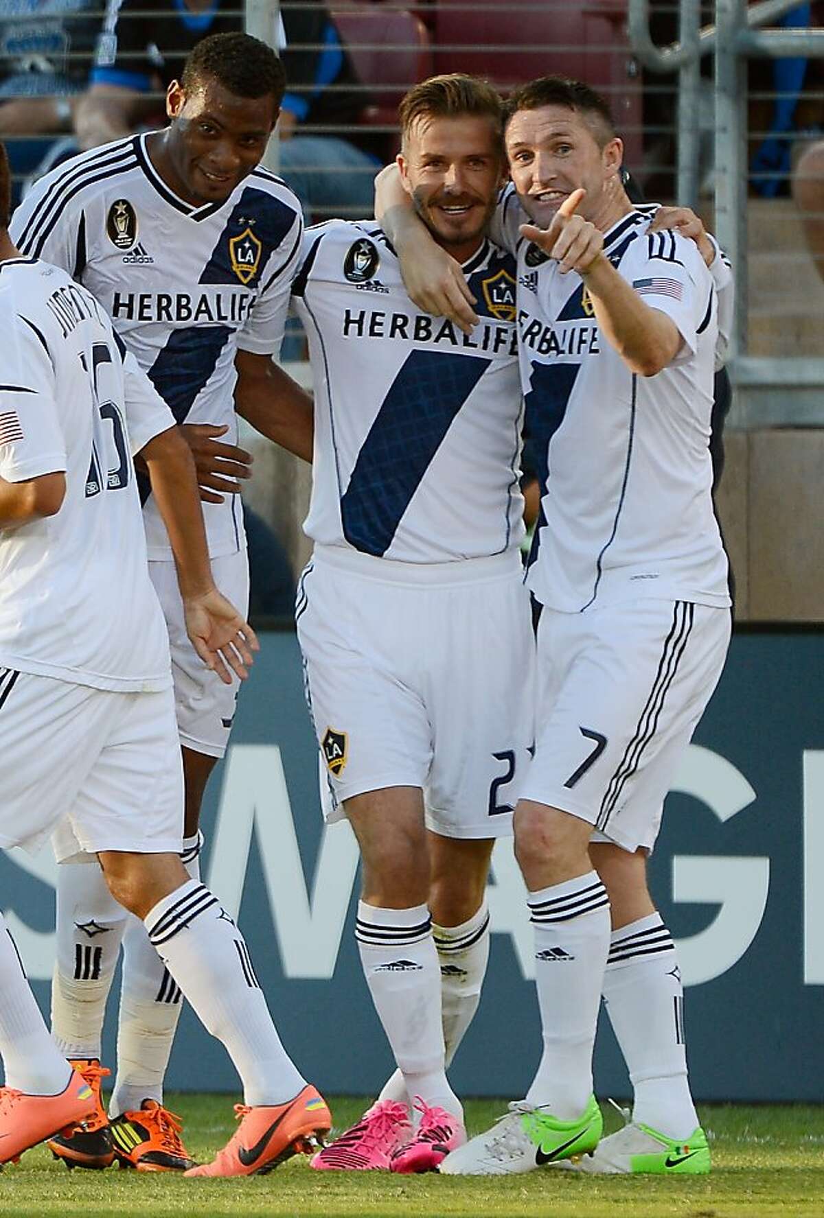 PALO ALTO, CA - JUNE 30: David Junior Lopes #3, David Beckham #23 and Robbie Keane #7 of the Los Angeles Galaxy celebrates after Beckham scored a goal on a free kick in the first half against the San Jose Earthquakes at Stanford Stadium on June 30, 2012 in Palo Alto, California. (Photo by Thearon W. Henderson/Getty Images)