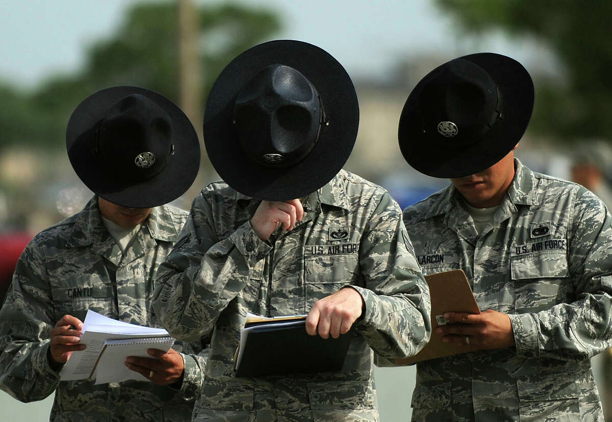 Military Training Instructors, or MTIs, grade a candidate during MTI training at Lackland Air Force Base.