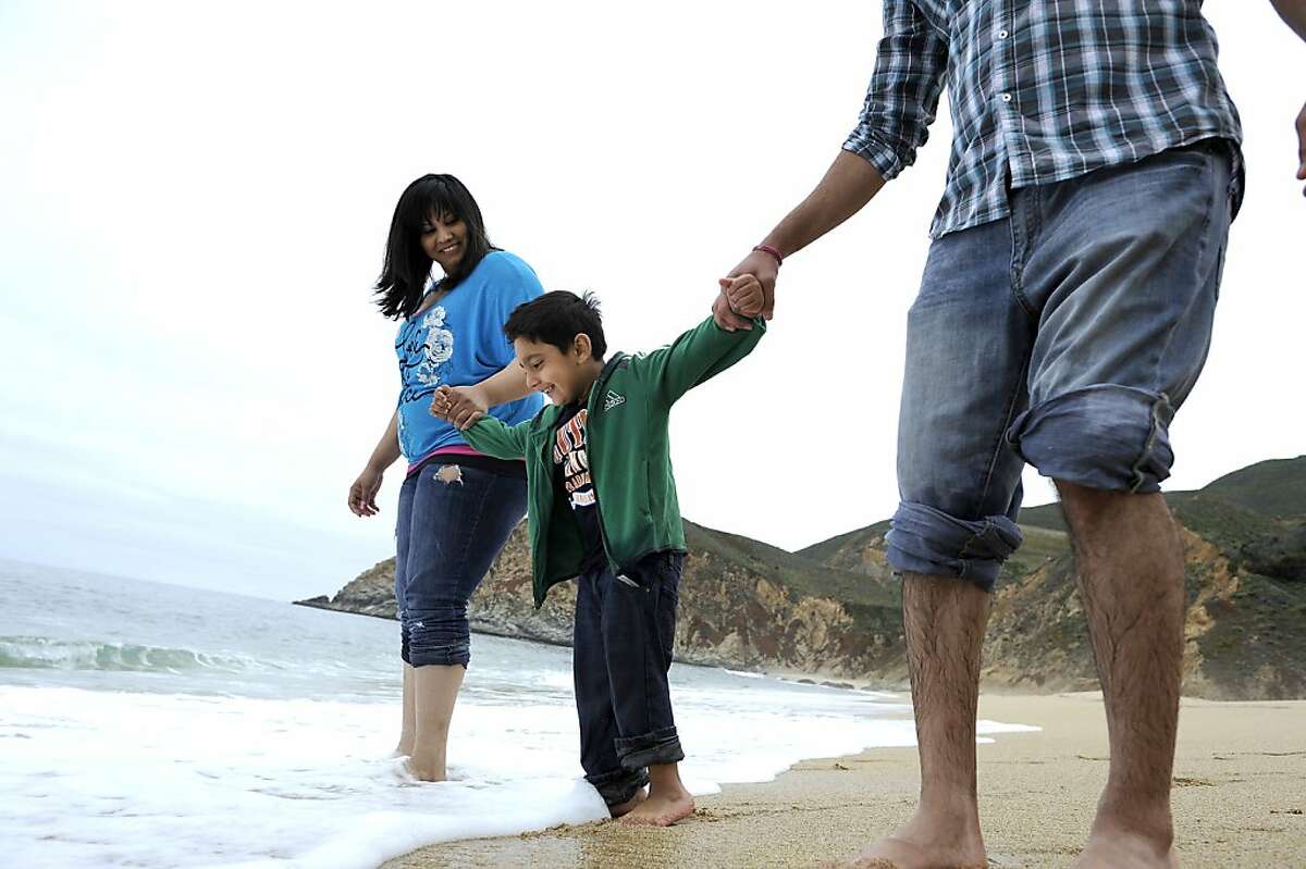 Pittsburg's Pawan Singh, right, wife Navi and son Jasmit visit Gray Whale Cove State Beach in Montara Friday.