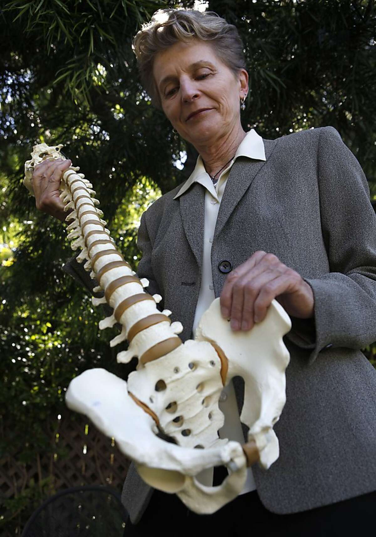 Chiropractor Lani Simpson examines a replica of a human spine and pelvic bone at her home in Berkeley, Calif. on Thursday, June 7, 2012. Simpson is a leading expert on osteoporosis, a condition which causes bones to become brittle and fragile.