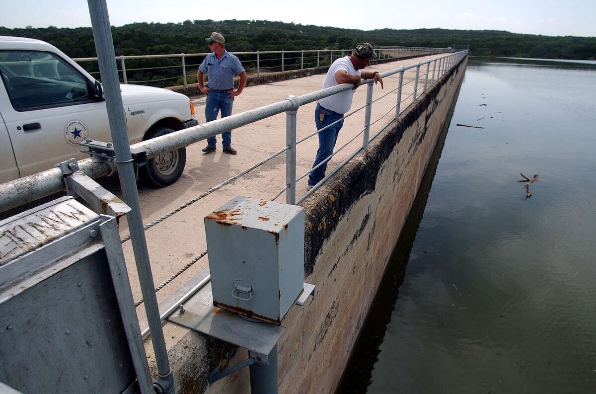 Then Vice-President of the BMA Water Board Guy Cooper (right) and BMA employee Wayne Salzman, surveyed the Medina Dam on Thursday, July 11, 2002. The water level reached nearly a foot and a half to the top of the dam during the peak of the storms.