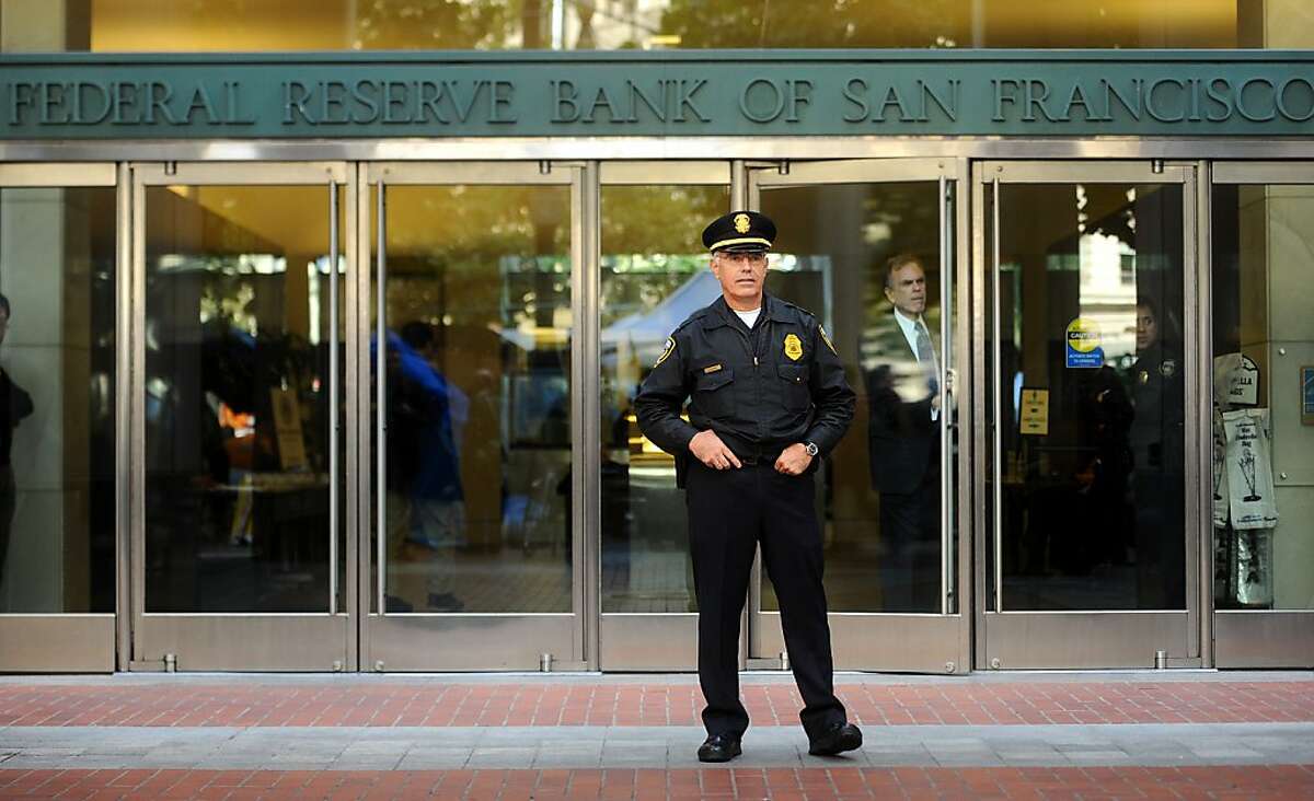Officer Schenone stands guard in front of the Federal Reserve Bank as protesters gather on Wednesday, Oct. 5, 2011, in San Francisco.