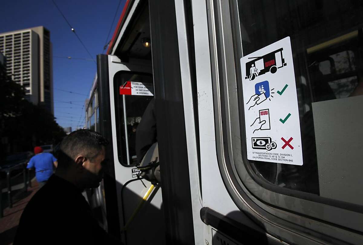 A sign at the back door of a MUNI bus lets riders know they can board there at Market and Van Ness in San Francisco, Calif., Monday, July 2, 2012. Monday was the first commuting day where back-door boarding was allowed on buses.