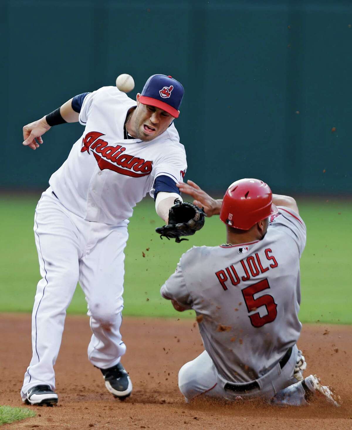 Los Angeles Angels' Albert Pujols (5) steals second base as the throw hits his shoulder and ricochets past Cleveland Indians second baseman Jason Kipnis in the fourth inning of a baseball game Monday, July 2, 2012, in Cleveland.