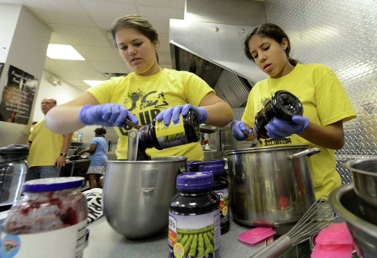 Julia Brown, left and Mya Johnson dole out large amounts of jelly at the JC Club in Albany, N.Y. for the 2012 JC Club Summer feeding program July 2, 2012. Many peanut butter and jelly sandwiches were made from the jelly. (Skip Dickstein/Times Union)