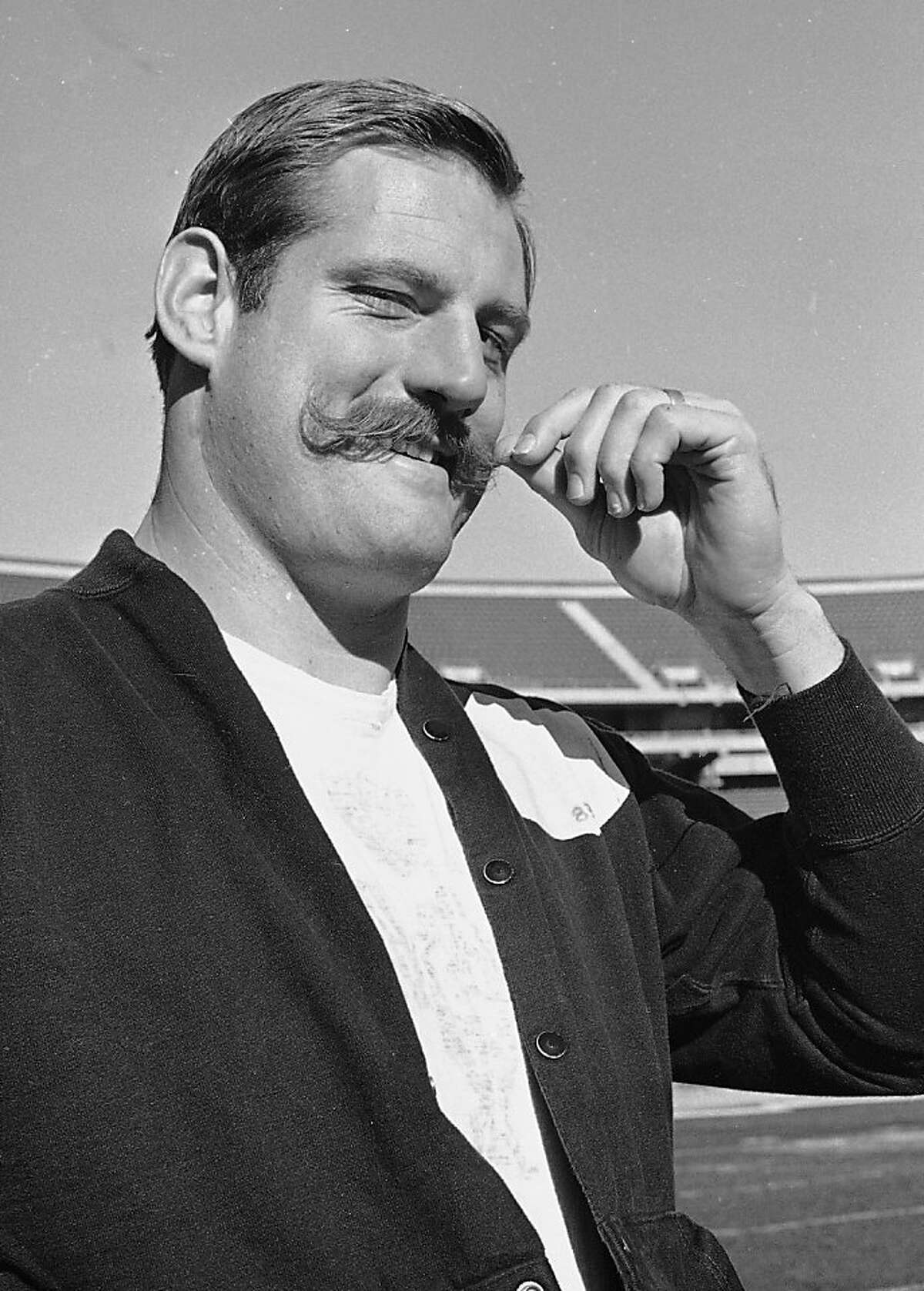FILE - In this Jan. 3, 1968, file photo, Oakland Raiders defensive end Ben Davidson twirls his handlebar moustache in Oakland, Calif., as he contemplated the coming meeting with the Green Bay Packers in the NFL championship game. Davidson, the hulking defensive end who starred for the Raiders in the 1960s before becoming a famous television pitch man, died Monday night, July 2, 2012. He was 72. (AP Photo/Ernest Bennett)