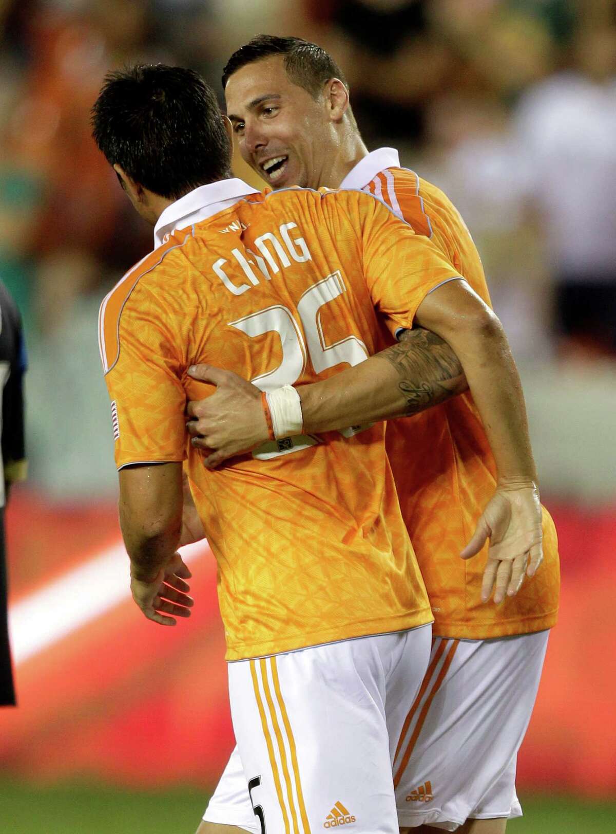 HOUSTON, TX - JUNE 30: Brian Ching #25 of the Houston Dynamo is congratulated by Geoff Cameron #20 of the Houston Dynamo after scoring on a penalty kick in the 83rd minute against the Philadelphia Union at BBVA Compass Stadium on June 30, 2012 in Houston, Texas.
