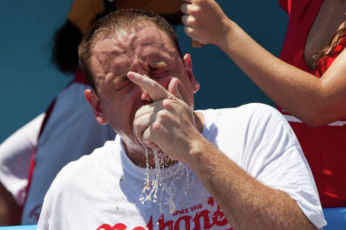 NEW YORK, NY - JULY 04: Competitive eater Joey Chestnut competes in the Nathan's Famous International Hot Dog Eating Contest at Coney Island on July 4, 2012 in the Brooklyn borough of New York City. Chestnut won the men's division by successfully tying his own world record by eating 68 hot dogs in 10 minutes.