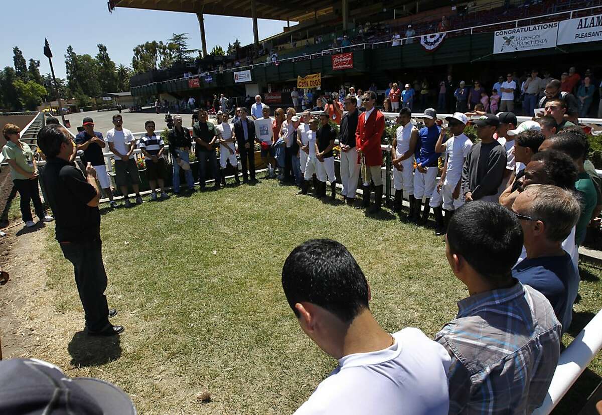 Jockeys and race track employees gather in the winner's circle to pay tribute to Jorge Herrera at the Alameda County Fair in Pleasanton, Calif. on Friday, July 6, 2012. Herrera was the jockey who died while riding Morito in the eighth race on Thursday.