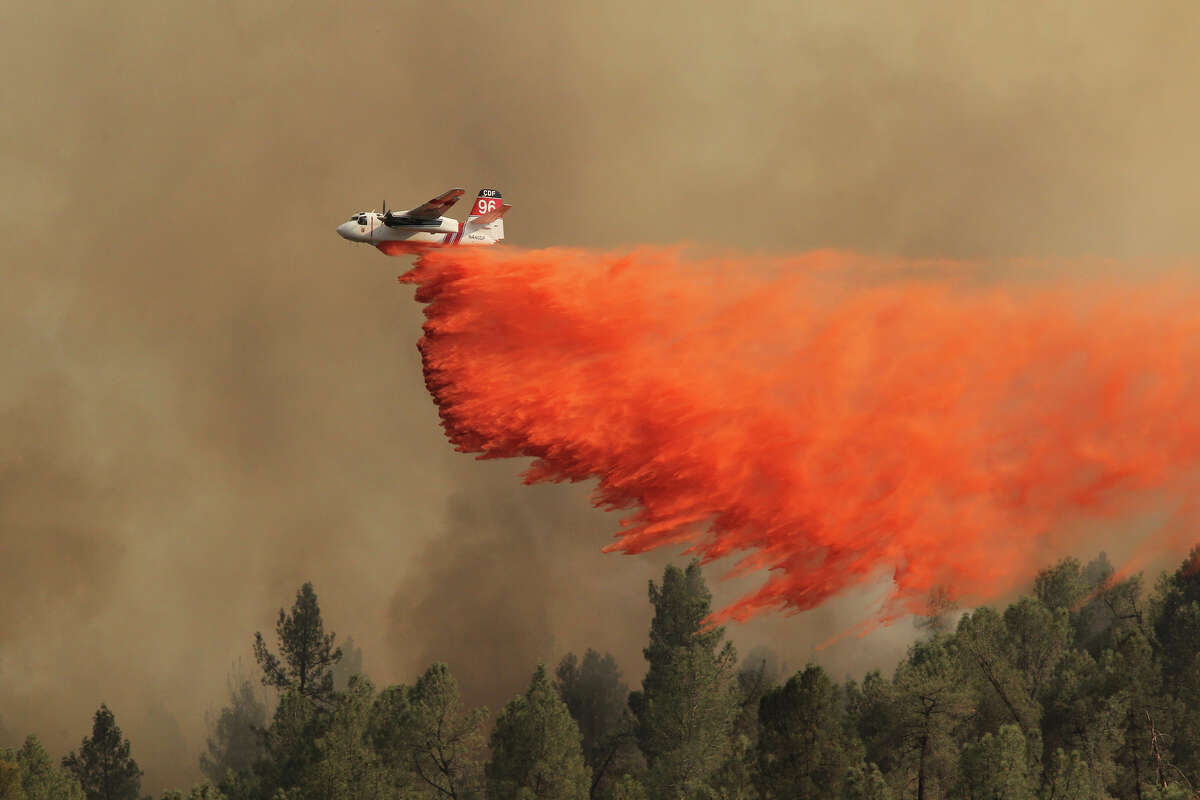 A California Department of Forestry and Fire Protection air tanker works the Dale Fire Thursday, July 5, 2012, near Happy Valley, Calif. Authorities say a 1,200-acre wildfire near Redding is 30 percent contained and has destroyed two outbuildings. Officials say five homes were damaged but firefighters were able to save them all.