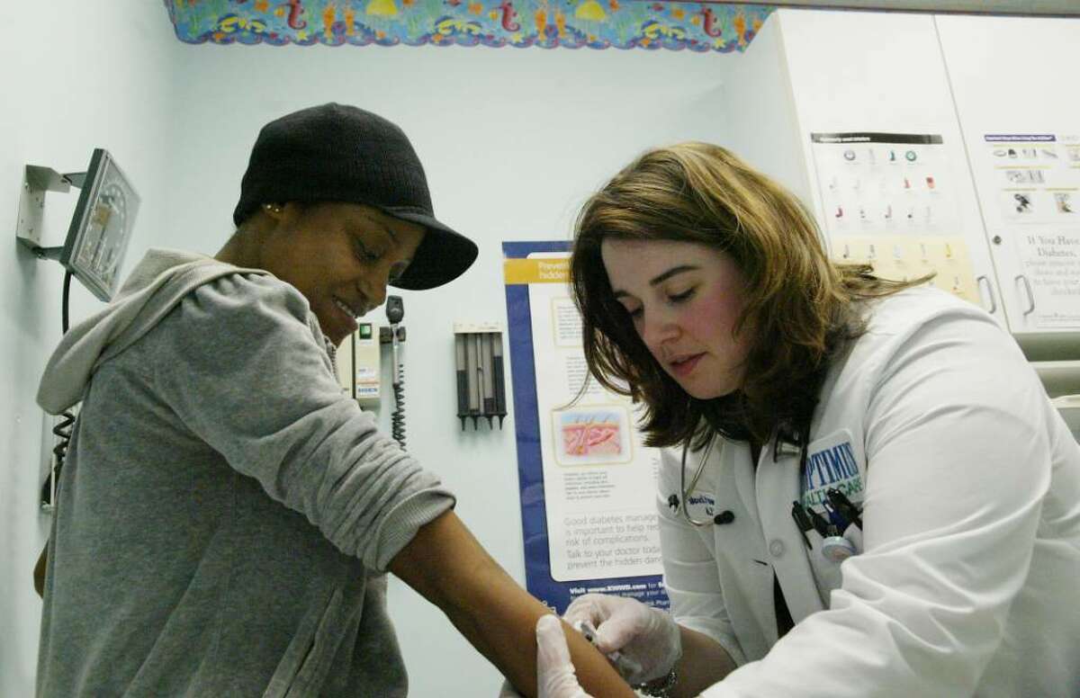 (R) Family Nurse Practioner, Marcie Panadada gives (L) Chieyan Hines a shot at the Park City Primary care Center in Bridgeport, Wednesday, Oct. 28, 2009.