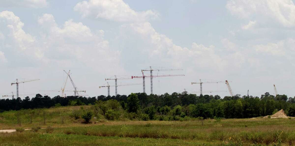 Construction cranes rise above the trees at the site of the Exxon Mobil Corp. campus near The Woodlands. The 385-acre tract is being developed, near I-45 and the Hardy Toll Road, as the energy corporation's new corporate campus. The development will include multiple low-rise office buildings; lab, conference and training centers; a child care facility; and a wellness center.