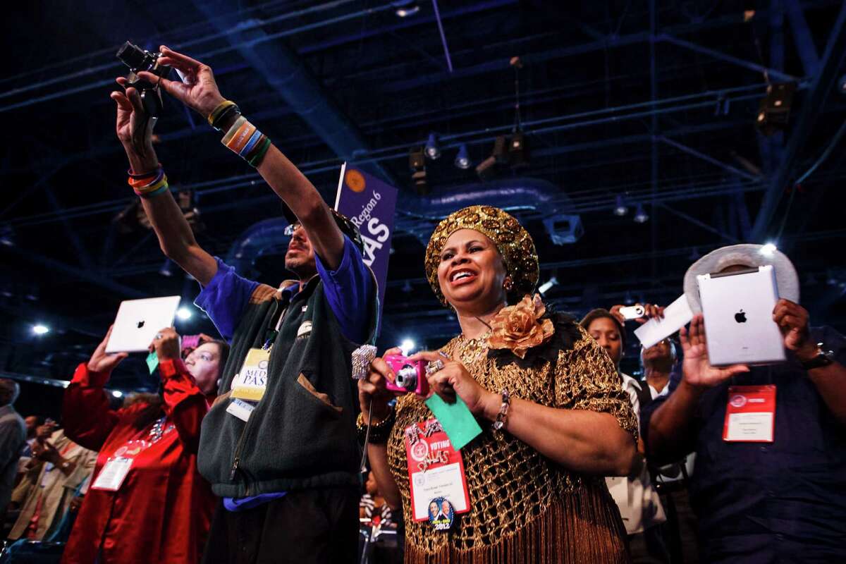 Clara Brown Trimble, center, and others snap picture as Attorney General Eric Holder speaks at the NAACP National Convention at the George R. Brown Convention Center on Tuesday. Holder, held in contempt of Congress during the investigation of the "Fast and Furious" gun-running operation, got a standing ovation.