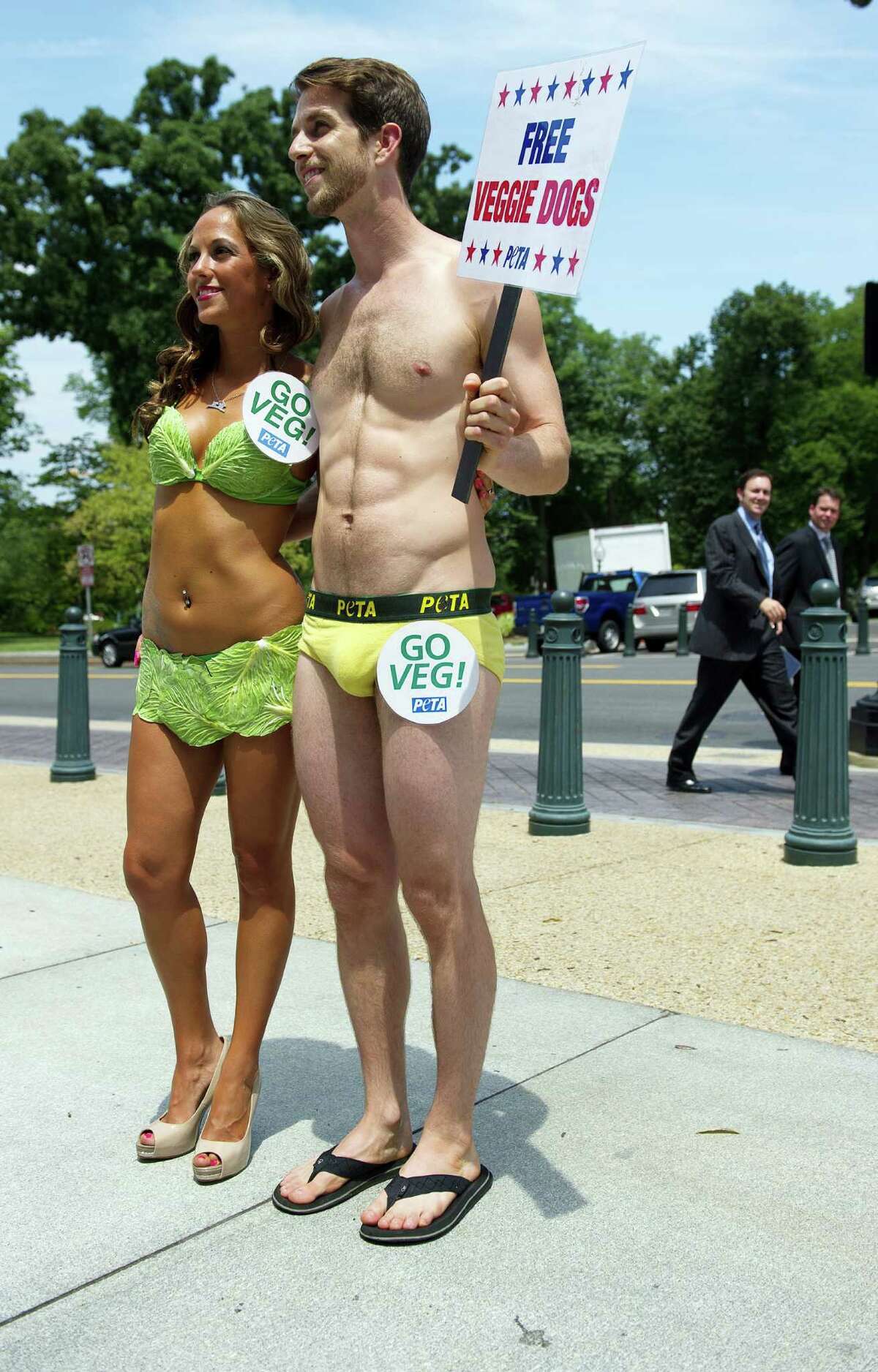 PETA's "Banana Boy" stands with one of the "Sexy Lettuce Ladies", wearing bikinis made of strategically placed lettuce leaves, as they give away vegan hotdogs for members of Congress and their staff on Capitol Hill in Washington, DC, July 11, 2012. AFP PHOTO/Jim WatsonJIM WATSON/AFP/GettyImages