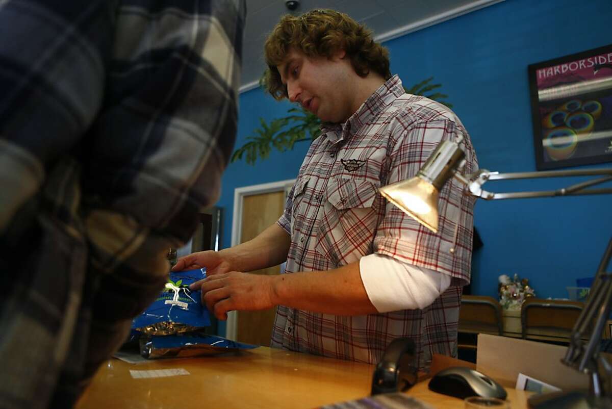 Steve Shulenberger, sales staff, assists a customer at the smokables, edibles, concentrates and seeds counter at the Harborside Health Center on Wednesday, November 30, 2011 in Oakland, Calif.