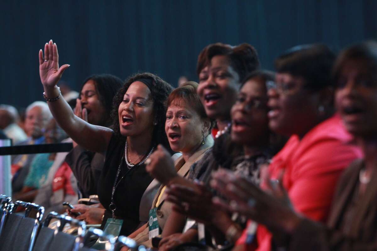 Stephanie Couser of Dallas, at left with arm raised, attends the NAACP convention on Thursday, July 12, 2012.