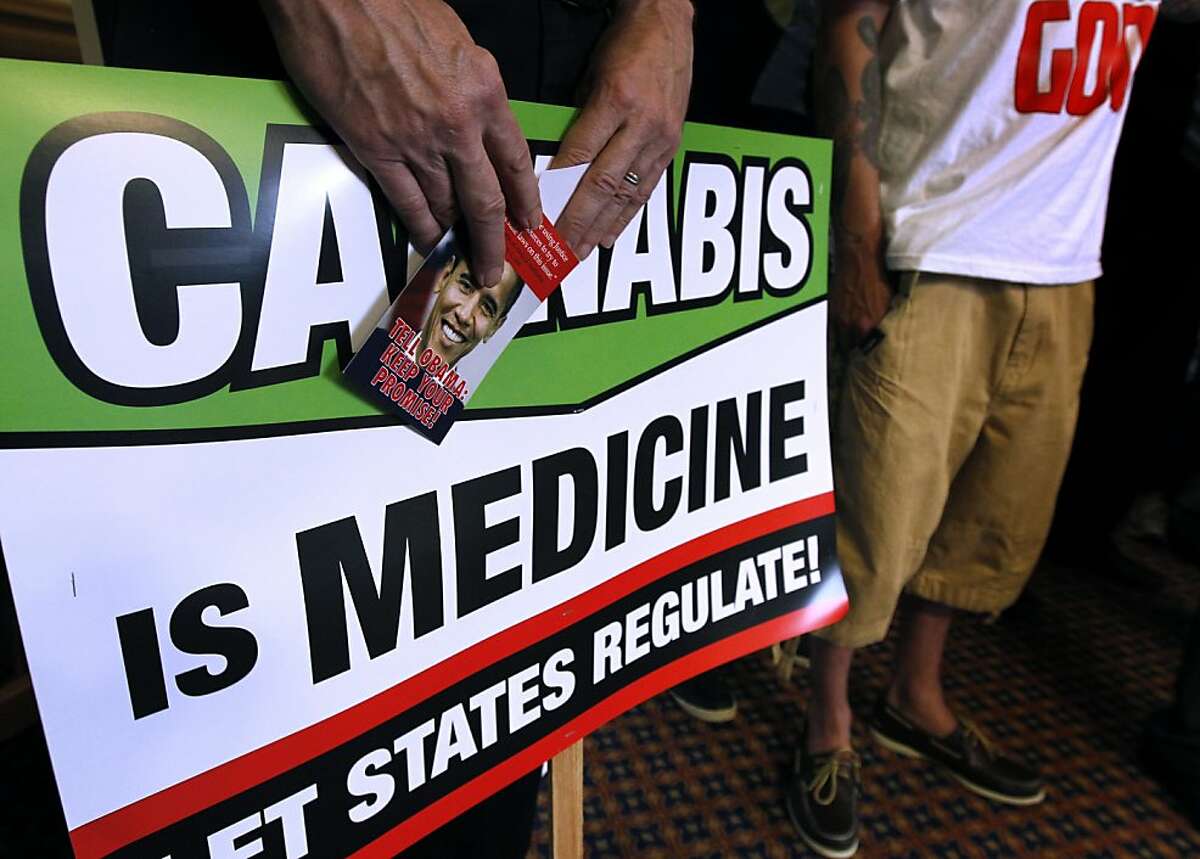 Dale Gieringer, director of California NORML, holds signs at a news conference called to criticize the federal government's threatened plan to seize assets and shut down the Harborside Health Center medical marijuana dispensary in Oakland, Calif. on Thursday, July 12, 2012.