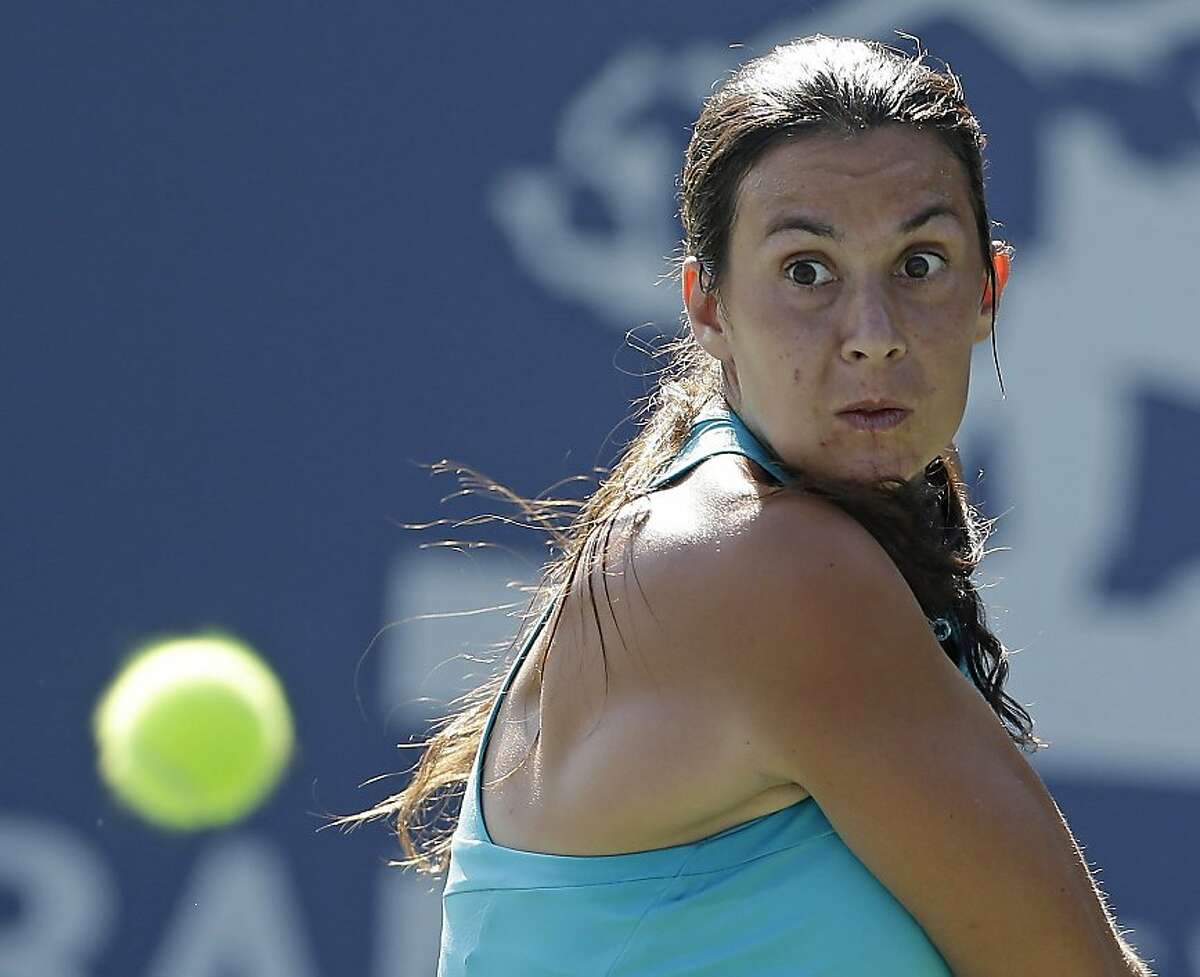Marion Bartoli, of France, returns to Mallory Burdette, of the United States, during the Bank of the West tennis tournament Thursday, July 12, 2012, in Stanford, Calif. (AP Photo/Marcio Jose Sanchez)