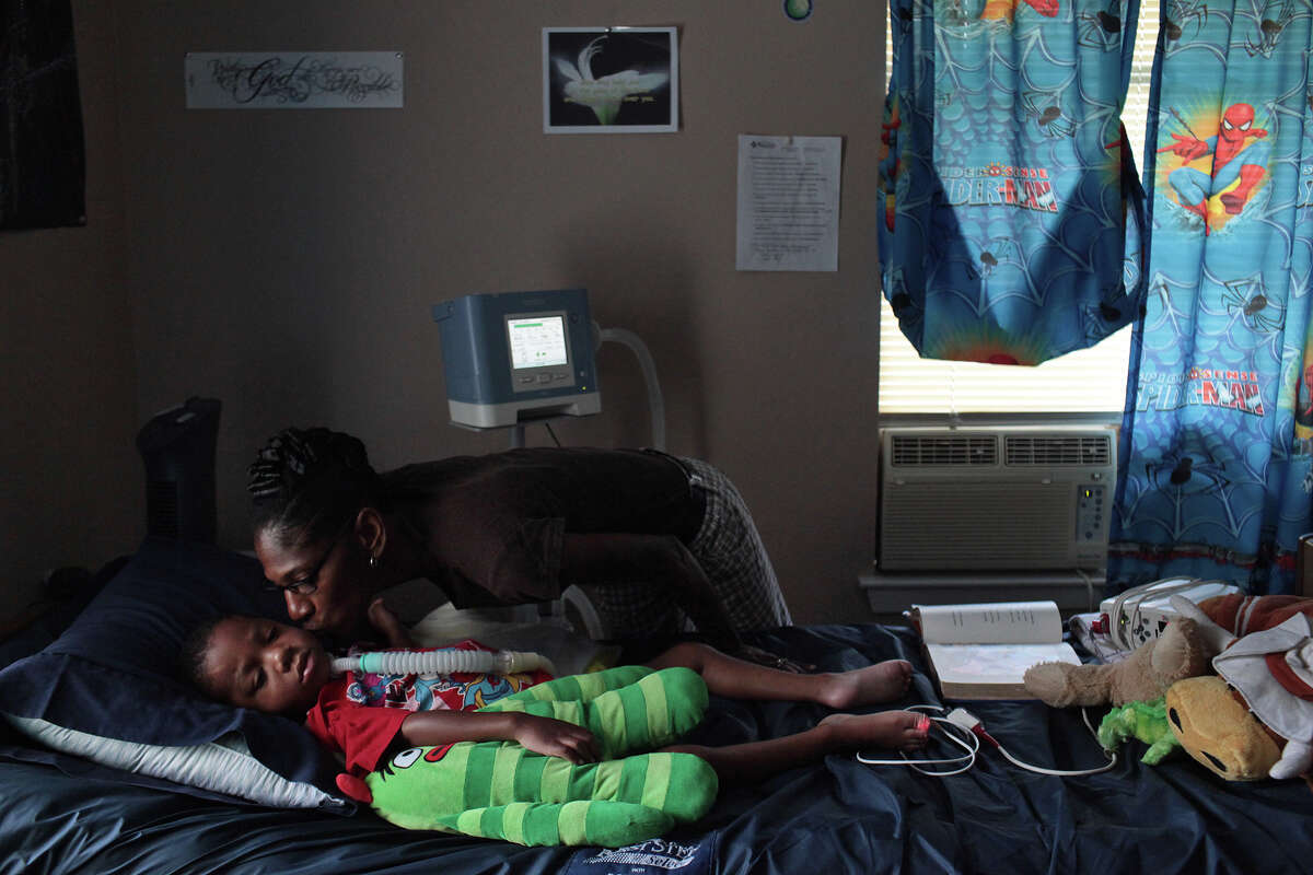 Rhodena Matthews, kisses her grandson, Braylon Nelson, 2, who was paralyzed in a road rage accident, at his home in San Antonio on Friday, June 29, 2012.