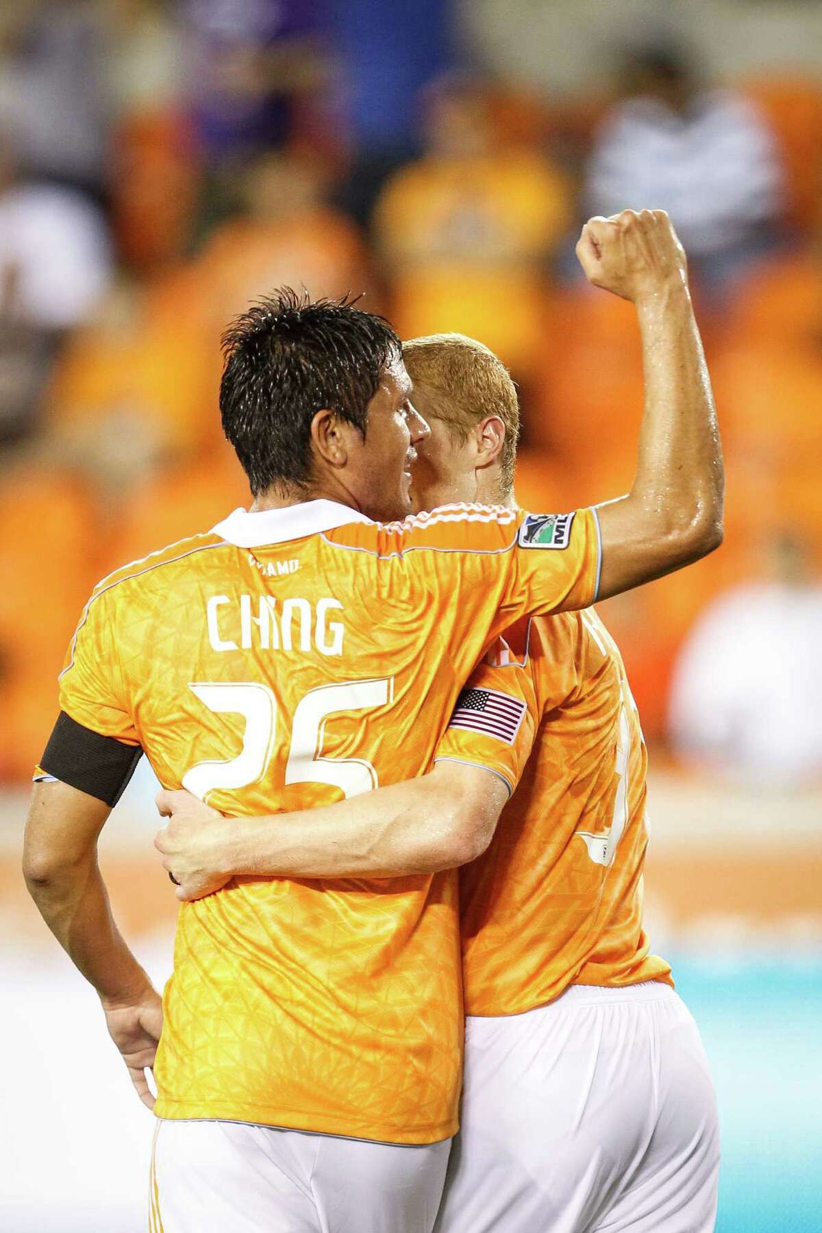Houston Dynamo forward Brian Ching (25) gets a hug from Andre Hainault (31) after Ching scored a penalty kick to put the Dynamo up 4-0 during the Houston Dynamo vs. D.C. United MLS soccer game at BBVA Compass Stadium, Sunday, July 15, 2012, in Houston.