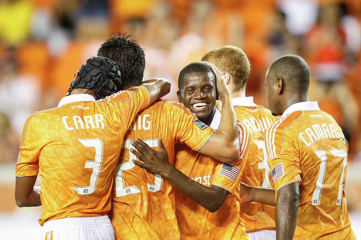 Houston Dynamo forward Brian Ching (25) gets a hug from Houston Dynamo forward Calen Carr (3) and Houston Dynamo forward Boniek Garcia (27) after Ching scored a penalty kick to put the Dynamo up 4-0 during the Houston Dynamo vs. D.C. United MLS soccer game at BBVA Compass Stadium, Sunday, July 15, 2012, in Houston.