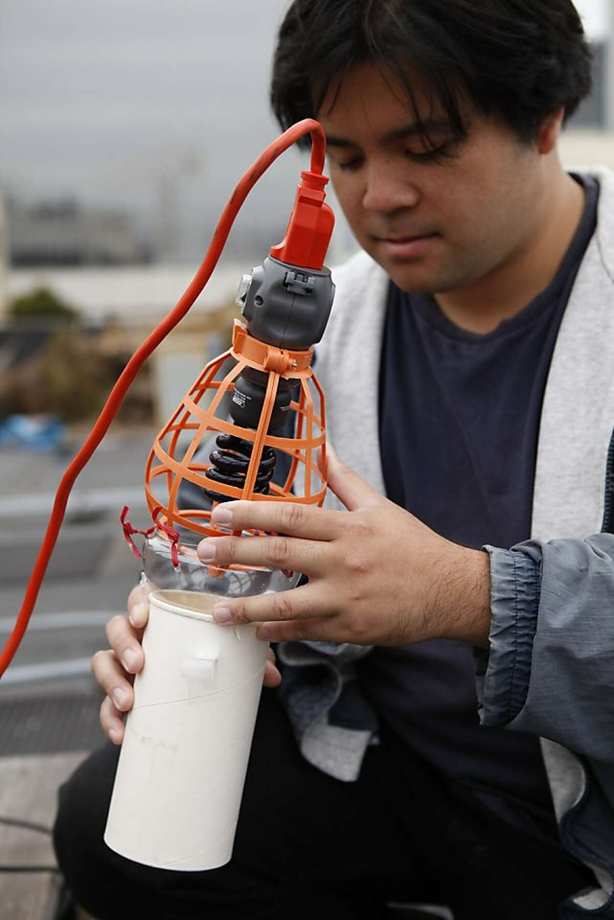 SF State systemic biology graduate student Christopher Quock is seen with a diy light trap in the Chronicle's rooftop garden on Thursday, June 21, 2012 in San Francisco, Calif.