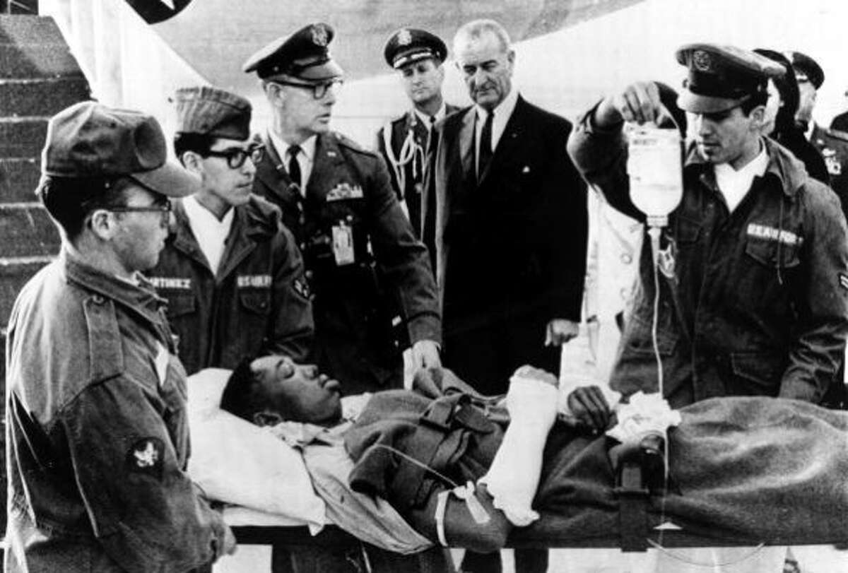 Lyndon B. Johnson looks on as a U.S. serviceman wounded in Vietnam is gently lifted from a plane, San Antonio, Texas, December 24, 1966. Lyndon B. Johnson (1908-1973) became the 36th President of the United States, serving 1963-1969. (Popperfoto/Getty Images)