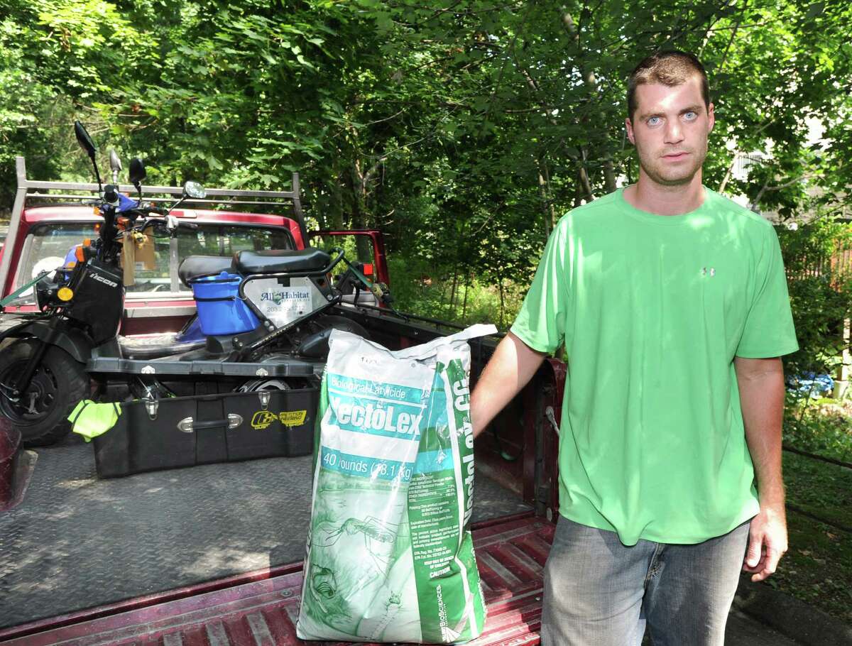 John McKenna of All Habitat Services Inc. with a bag of VectoLex, a larvicide used to kill mosquitoes during the larval stage of their development, on Lockwood Lane in Riverside, Tuesday afternoon, July 17, 2012.