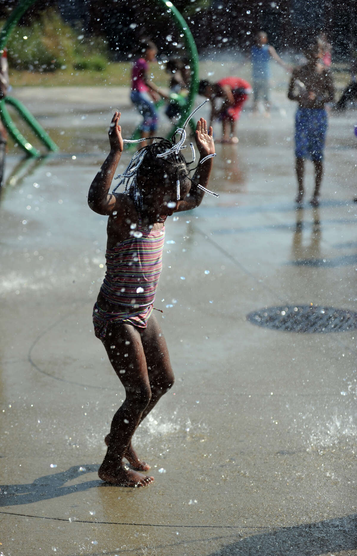 Four-year-old Nia Cunningham plays in the splash pad at Luis Muñoz Marin Park in Bridgeport, Conn. Tuesday, July 17, 2012. The sprinkler park was partially funded by the Gathering of the Vibes festival which has been held at Seaside Park since 2007.