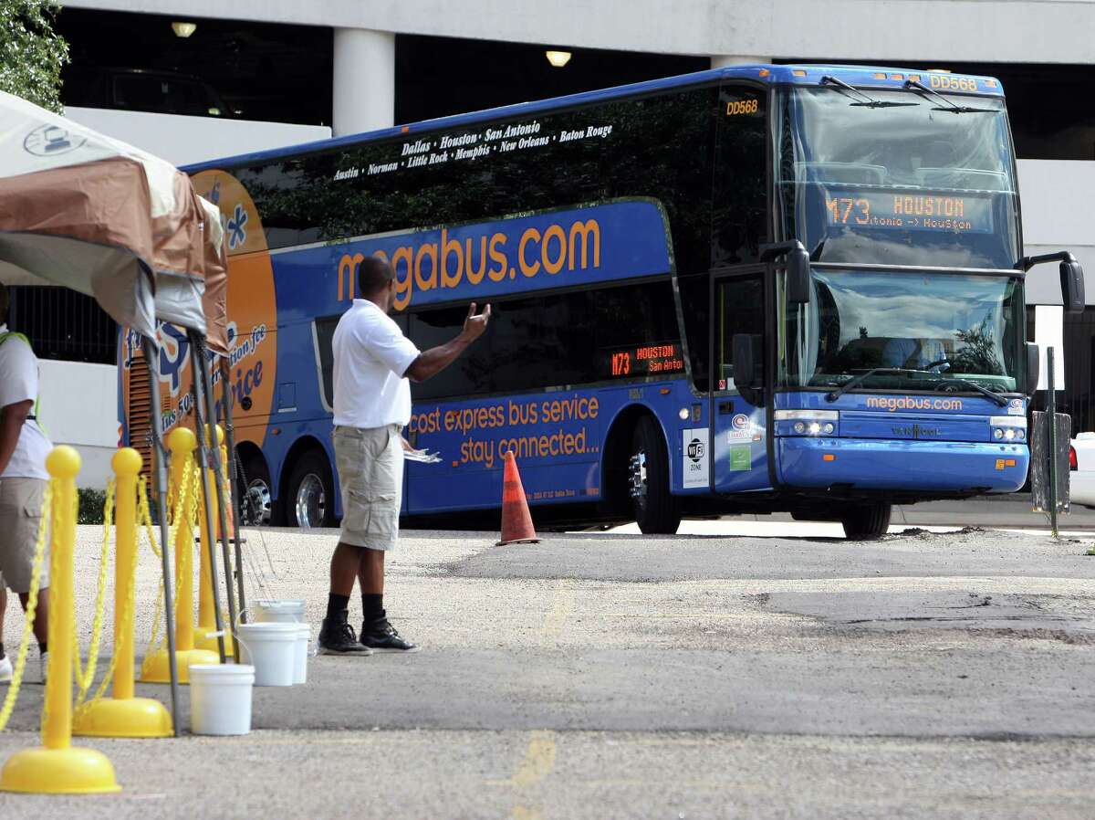 Megabus ground staff Richard Hutton signals a Megabus as it arrives at the pickup-departure area at Travis and Clay streets, Megabus is a low-cost inter-city bus company that has recently started service in Texas Tuesday, July 17, 2012, in Houston. ( James Nielsen / Chronicle )