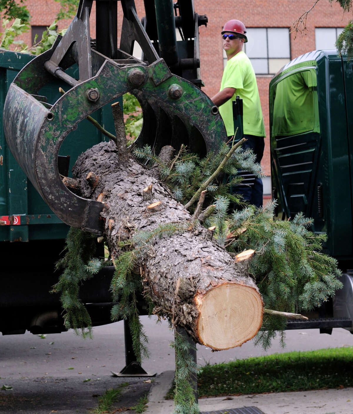 Heath Hobart, with the city forestry department, works a log loader at Rogers Park where city workers are still cleaning up debris from Wednesday storm, Thursday, July 19, 2012.