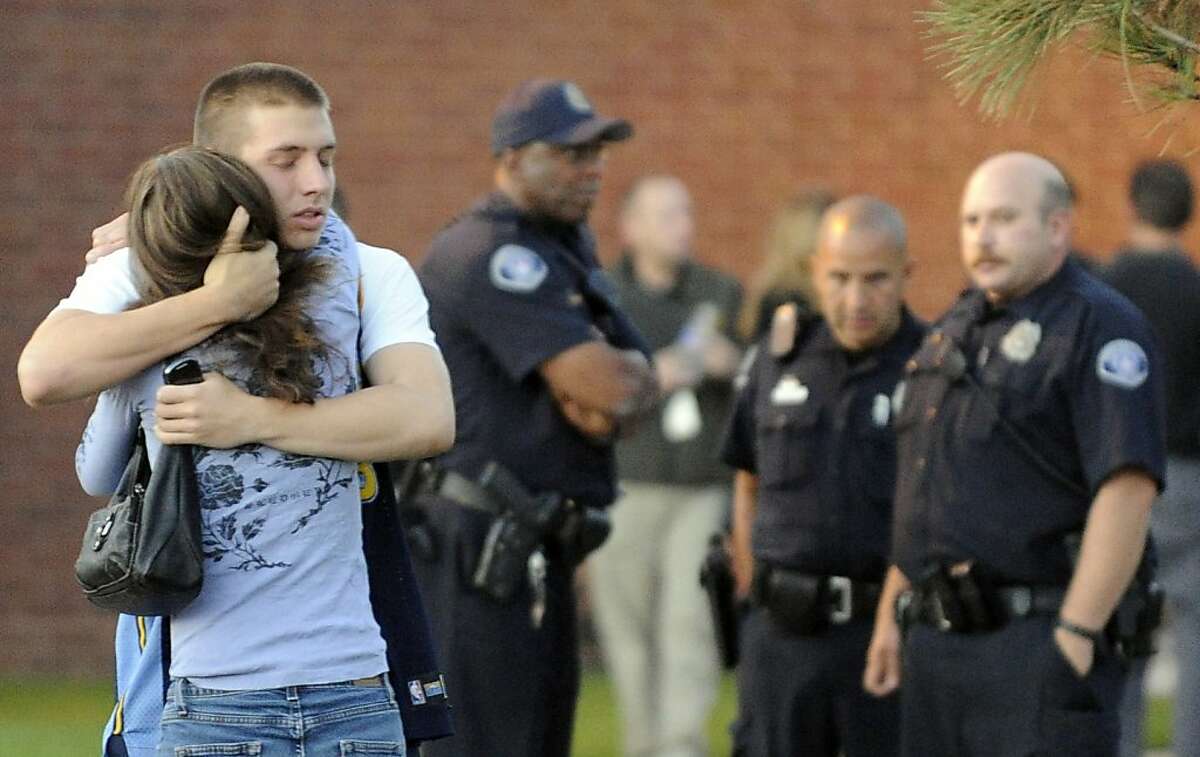 Witness Jacob Stevens, 18, hugs his mother Tammi after a police interview outside Gateway High School.