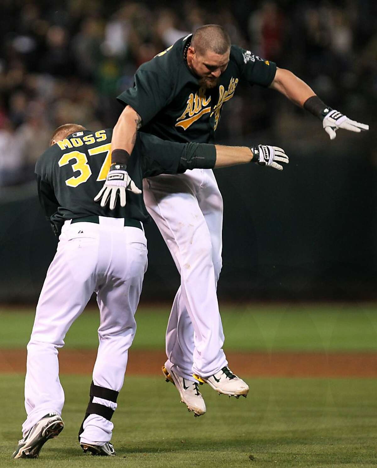 Oakland Athletics Brandon Moss celebrates his walk-off base hit that scored the A's winning run with teammate Jonny Gomes in the 9th inning of their MLB baseball game with the New York Yankees in Oakland Calif., Friday, July 20, 2012.