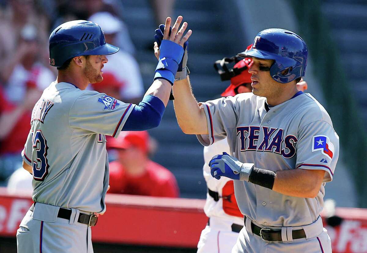 Craig Gentry, left, congratulates Ian Kinsler after they scored on Kinsley's home run against the Los Angeles Angels in the seventh inning of a baseball game in Anaheim, Calif., Saturday, July 21, 2012.