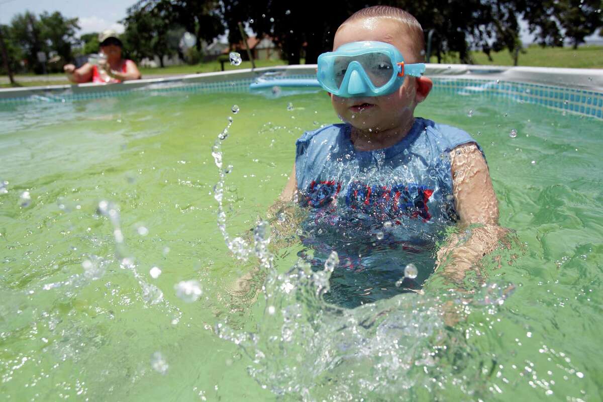 Mary Raley watches her grandson, Kaleb Simon, 5, swim at her home in Anahauc. The city is in a budget crisis; much of the problem arose after the water treatment plant broke down.