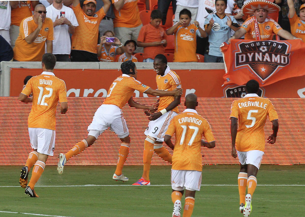 Houston Dynamo forward Macoumba Kandji (9) is congratulated by teammates after scoring a goal against the Montreal Impact during the first half of a major league soccer game at BBVA Compass Stadium on Saturday July 21, 2012 in Houston,Texas. (AP Photo/Houston Chronicle, J. Patric Schneider)