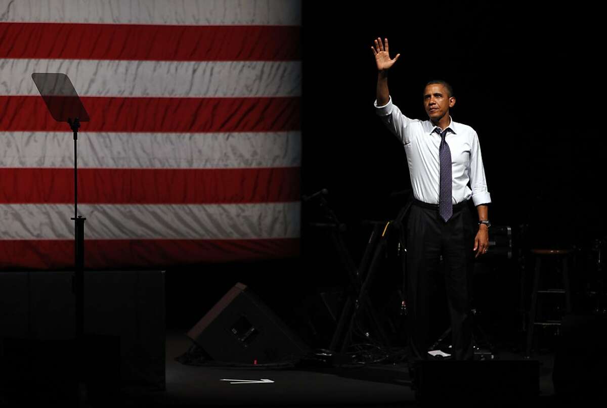 President Obama waves goodbye to the crowd after speaking at a fundraiser at the Fox Theater in Oakland, Calif., Monday, July 23, 2012.