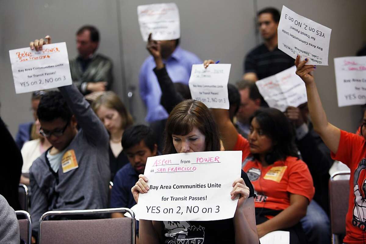 Aspen Dominguec, center, holds up a sign showing her support for free Muni fares for low-income youth while the Metropolitan Transportation Commission considers the issue in Oakland, Calif. on Wednesday, July 25, 2012.