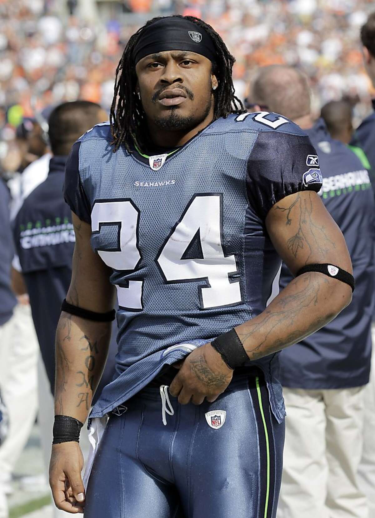 ADVANCE FOR WEEKEND EDITIONS, JULY 21-22 - FILE - FILE - In this Oct. 23, 2011 file photo, Seattle Seahawks running back Marshawn Lynch watches from the bench area during the second quarter of an NFL football game against the Cleveland Browns in Cleveland. Just one week before some camps open, three players critical to their teams' chances this season were arrested. Lynch, who served a three-game league suspension in 2009 for violating the personal conduct policy, was cited for DUI. (AP Photo/Amy Sancetta, File)